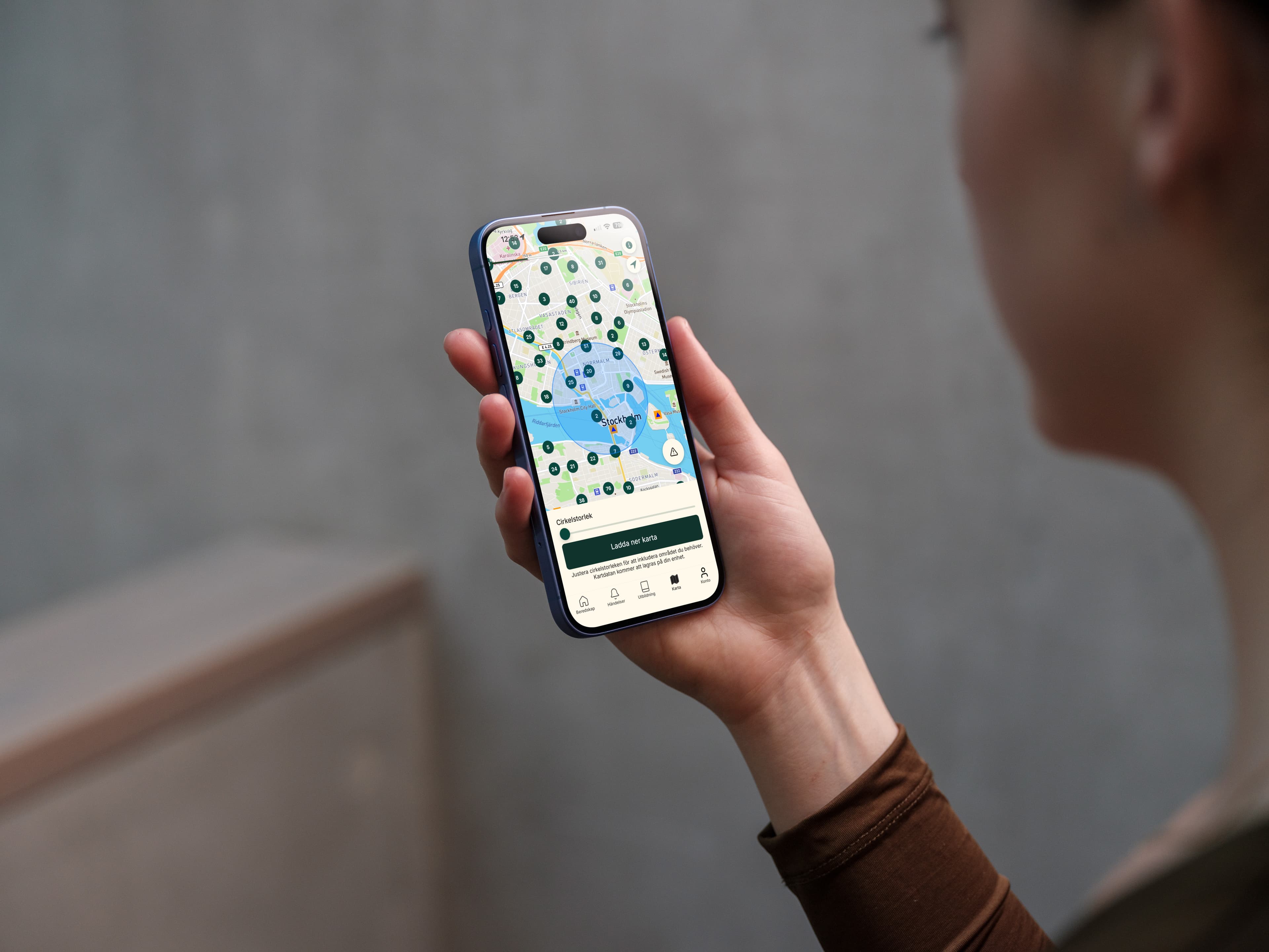 A person holding a phone with Bereddo's shelter map open — nearby shelters marked, with a button to download the map area